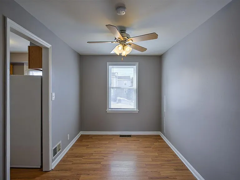 Large window and ceiling fan in a room at Colonial Park.