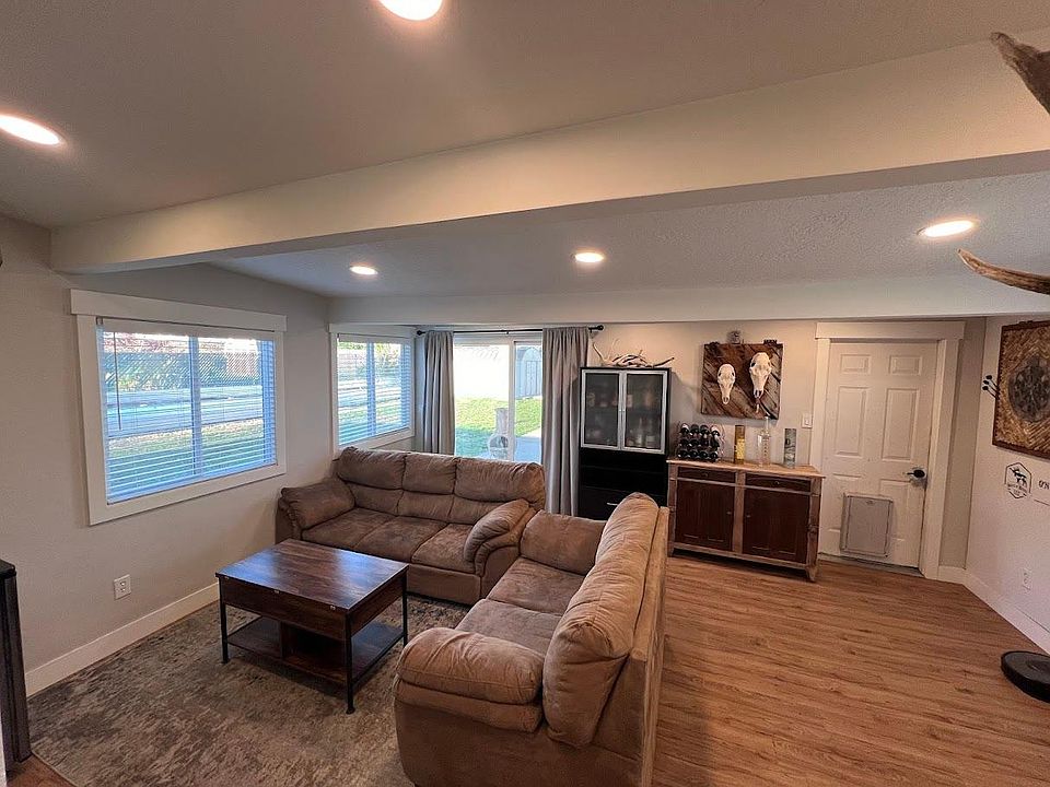 Sun room/living area with garage access, multiple windows and a large sliding glass door.