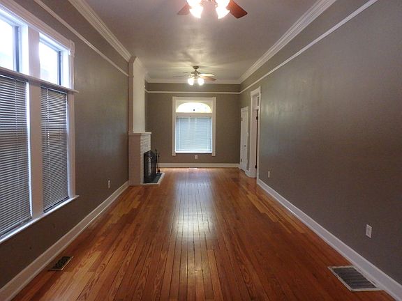Living room looking toward window at the front of the house. Fireplace on left. Mudroom/front door on right. Bedroom/office on right.