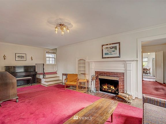 Front living room with wood burning fire place, crown molding and original hardwood floors. 