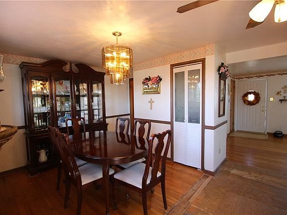 Original Hardwood Floors in 16x9 Dining Room w/ Beautiful Chandelier & Pantry flowing nicely from Living Room and opens into Kit