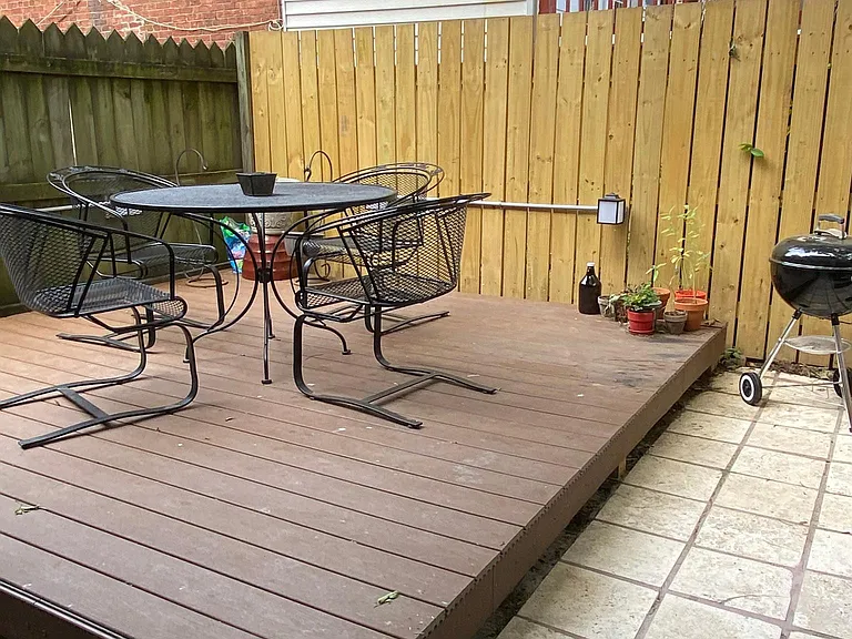 Fenced in back patio daytime view.
