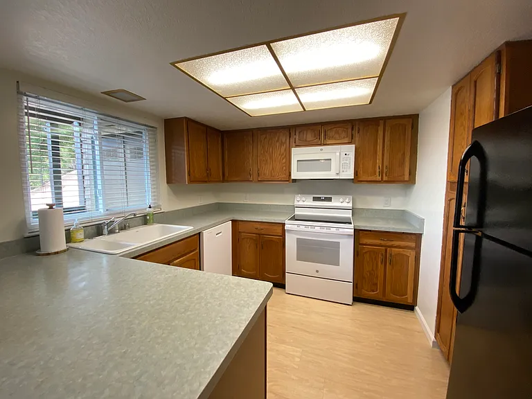 Kitchen with new dishwasher, oven, cooktop stove, and overhead microwave.