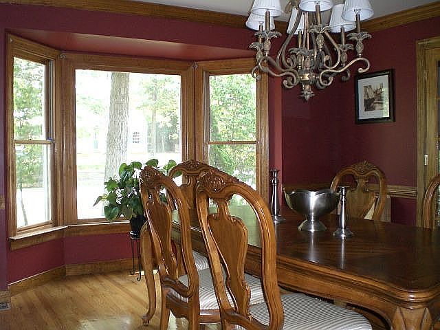 dining room w/ hardwood floors and crown molding