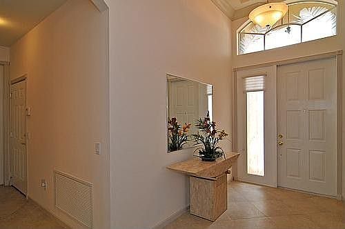 Foyer Features Ceramic Tile On Diagonal And Coffered Ceilings With Crown Moldings
