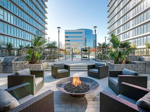 Outdoor fireplace, lounge seating, and BBQ area.