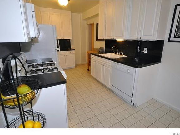 Updated eat-in-kitchen has custom cabinets and the appliances include a dishwasher, range, microwave