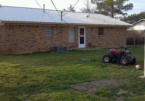 back yard is fenced in with a new storage building