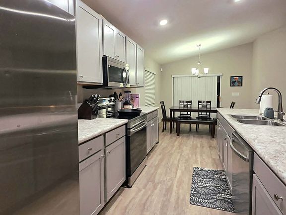 Stainless steel two-door refrigerator, oven, and dishwasher included. Sink has a garbage disposal. Plenty of cabinet storage and prep areas for home chefs.