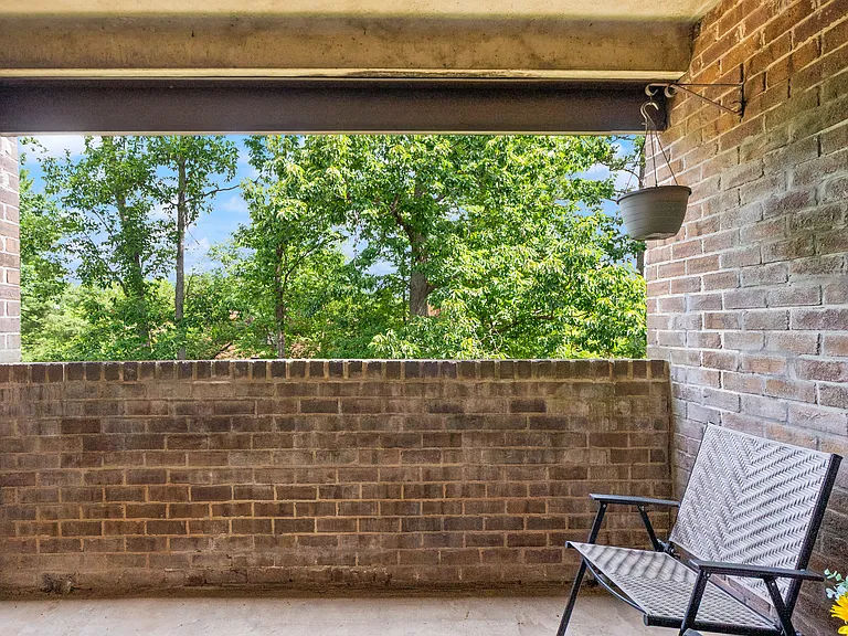 Balcony with beautiful tree-filled view that overlooks the green space.