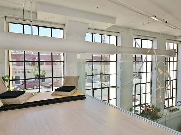 Loft mezzanine overlooking 17' tall wall of industrial windows