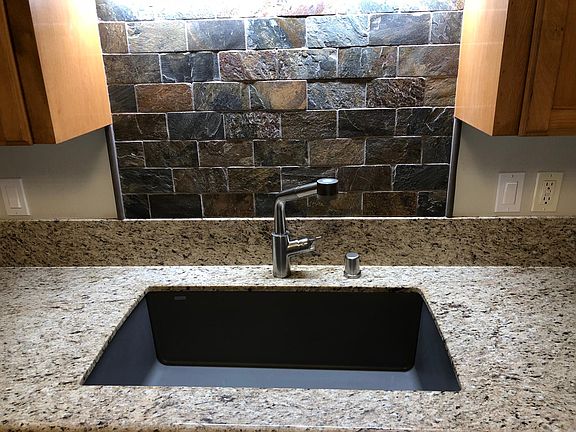 Large granite composite sink with custom slate stone backspl