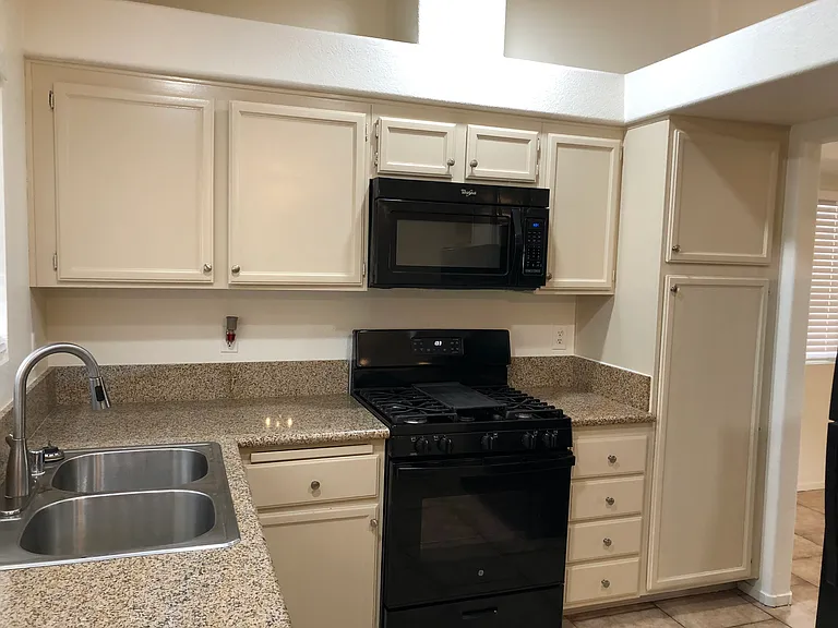 Kitchen includes over the range microwave oven -- black appliances.