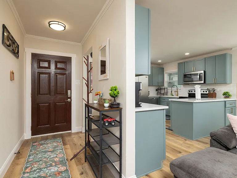 Bright, modern kitchen with stainless appliances, teal cabinets, and a spacious island_perfect for cooking, gathering, and enjoying a warm, stylish space.