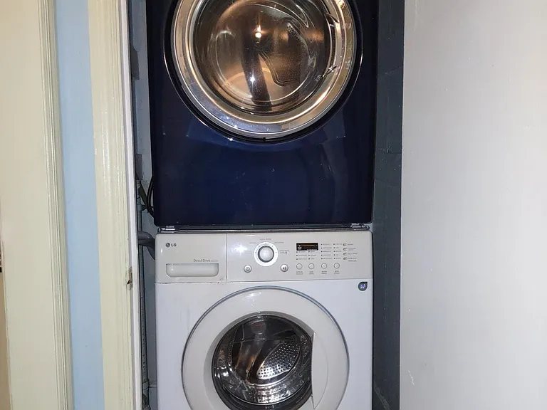 Full-sized washer and dryer in hallway closet.