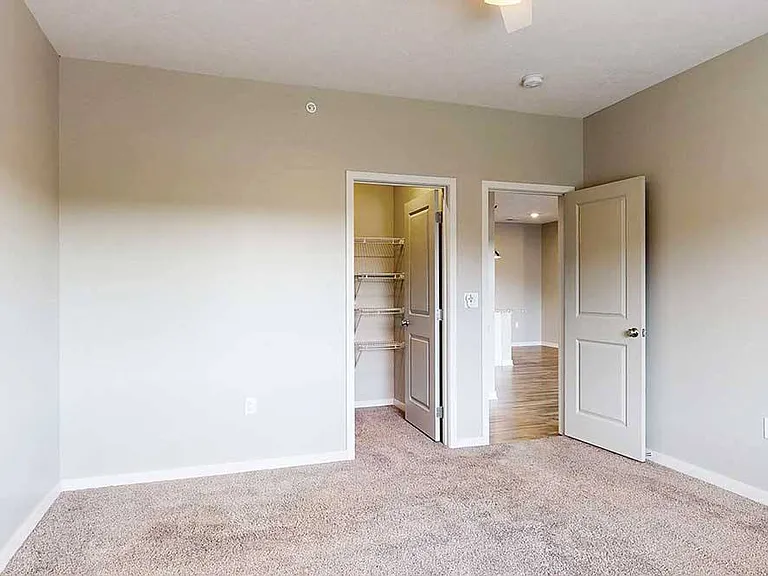 At the end of the day, unwind in a spacious bedroom featuring plush carpeting and a walk-in closet for easy organization.