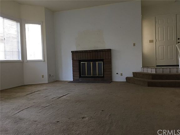 Spacious living room with wood/gas burning fireplace and tall ceilings.