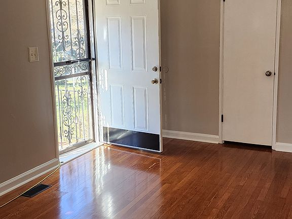 Living room with picture windows for natural light. Recess lighting and hardwood floors.