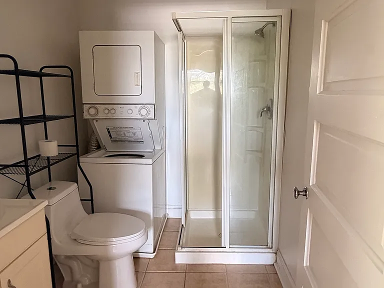 Bathroom with in-unit washer and dryer, walk in shower.