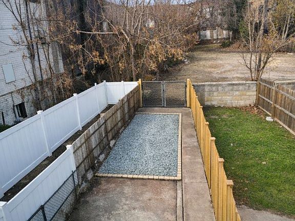 fenced in backyard with parking pad