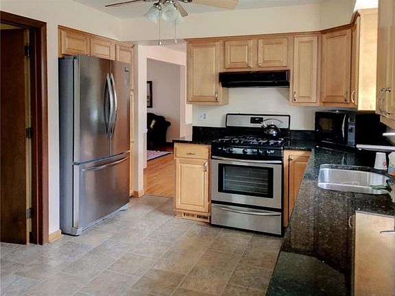 MAPLE KITCHEN WITH GRANITE COUNTERTOPS, AMPLE CABINETRY AND STAINLESS STEEL APPLIANCES