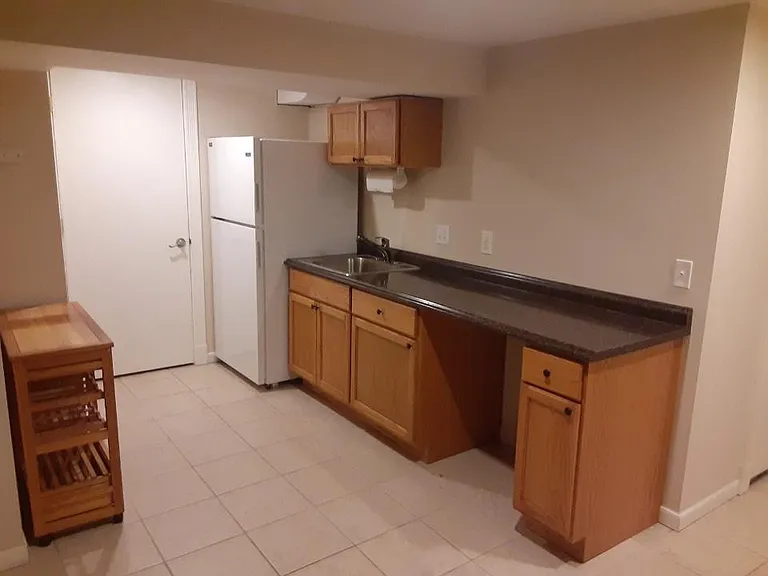 Lower-level Snack area with ceramic tile floor & next to laundry room & functioning newer fridge.