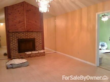 Living room
						:
						Vault ceiling with chandelier, fireplace, and entrance to dining area.