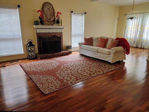 Spacious Living Room, Natural Light, Peaceful Light Colors with Real Brazilian Wood Floors, Vaulted Cathedral Ceilings, Bronzed Fireplace with Mantel. Nothing plastic here it's all Real! 
color used though-out this home is almost white hint of Buttercream
