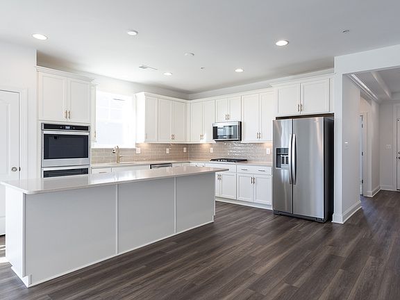 Island kitchen with white cabinets in a DRB Homes Starling II home in the Rosehill Manor community.