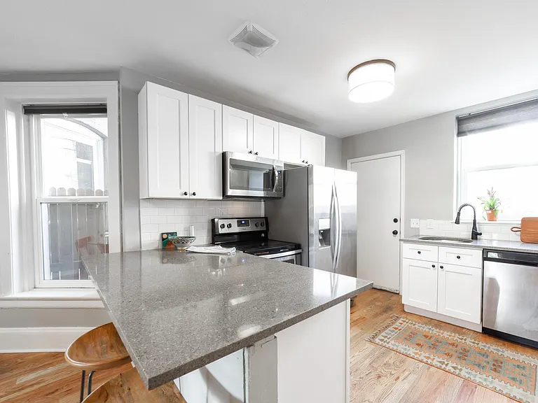 Stone counters, stainless appliances, dishwasher, and backdoor