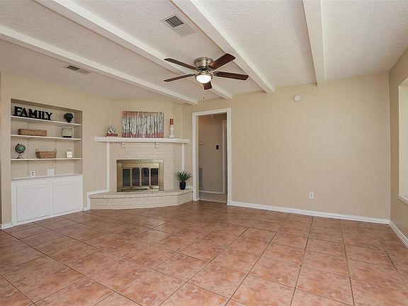 FAMILY ROOM - Corner wood-burning fireplace and pretty hearth for decorating. Updated ceiling fan.
