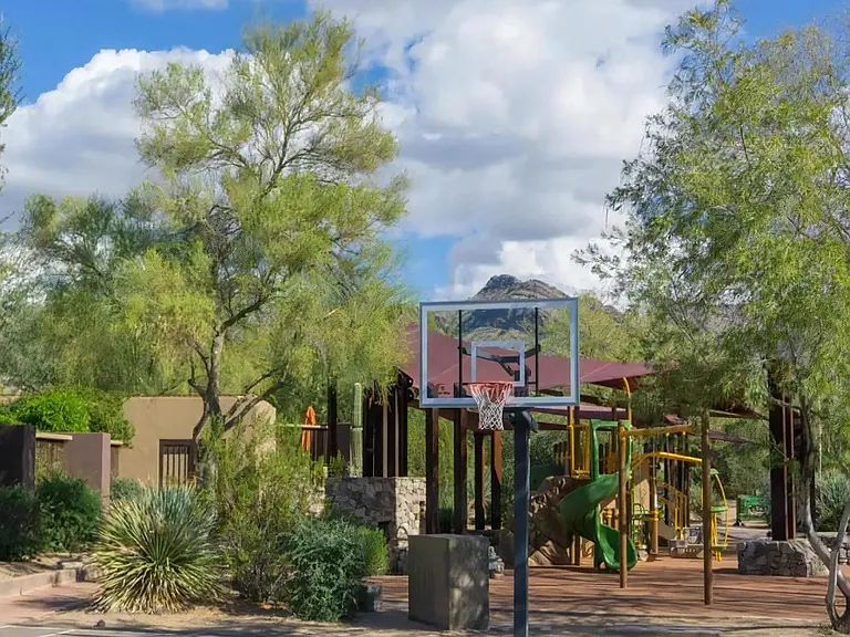 Children's Play Area with Slides, Swings, and Nearby Basketball Court