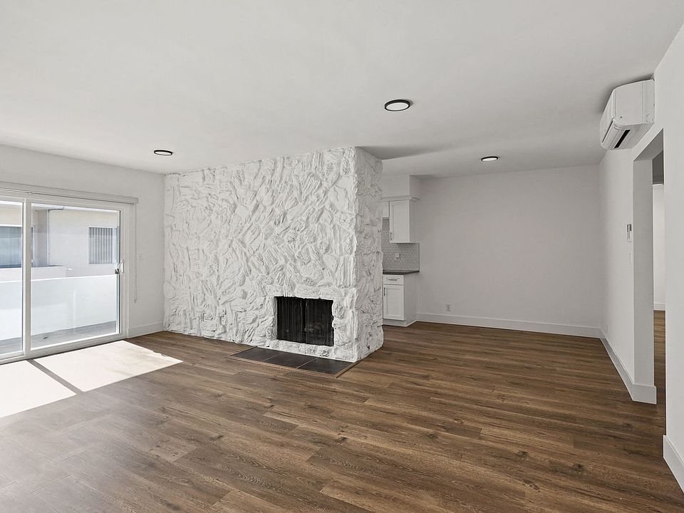 Living Room with Electric Fireplace, Vinyl Flooring, and Patio