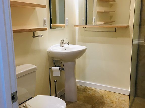 Gorgeous bathroom with handmade floating shelves and glass shower.