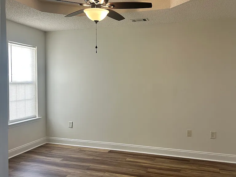 Bedroom 2 with tray ceiling and ceiling fan