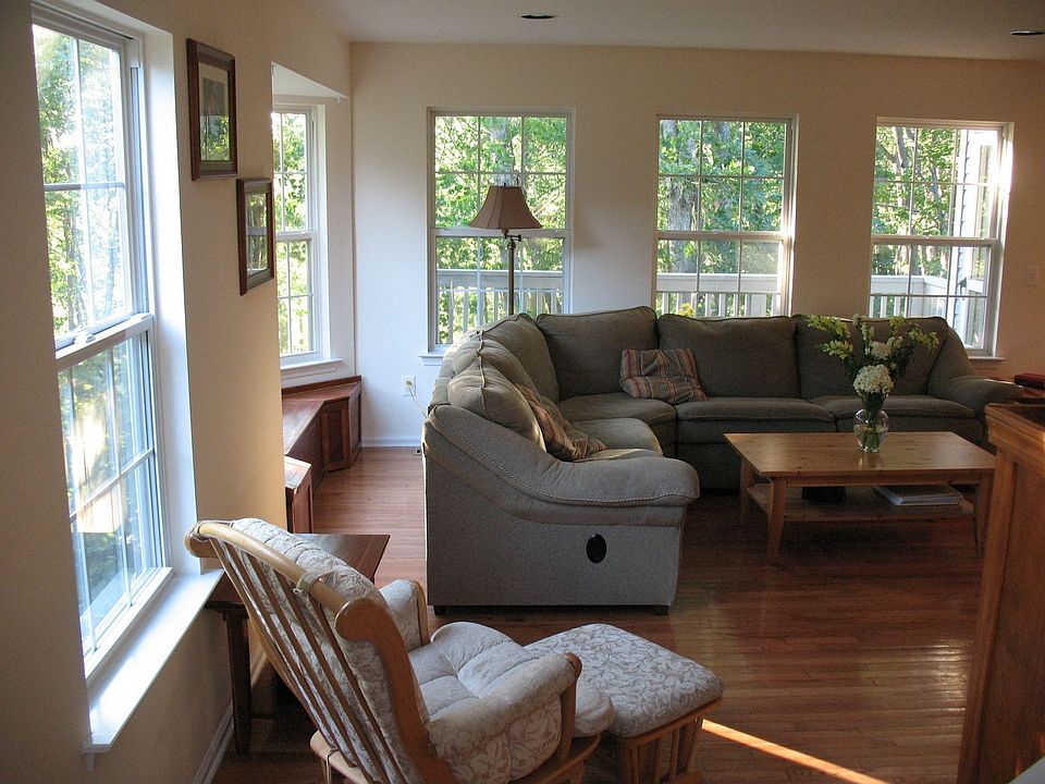 Hardwood floors, recessed lighting, rows of windows overlooking woods