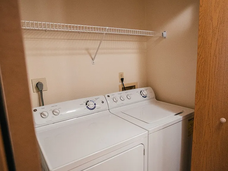 Washer/Dryer with shelving in hall closet