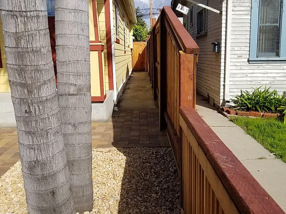 New redwood fence both provides privacy and allows for neighborly conversation with professionals living next door.