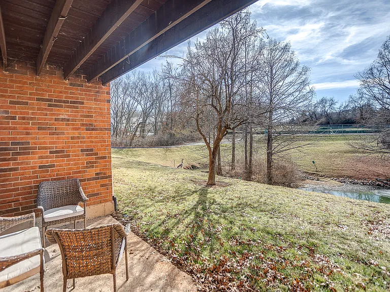 Patio overlooking the lake, tennis courts, and green space