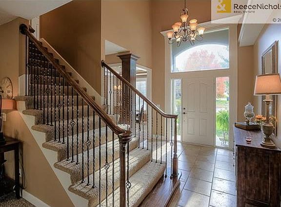 Gorgeous entry with updated light fixture, iron spindles and tile.