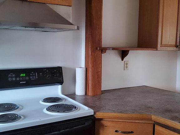 Counter and stove, at right is a microwave shelf with outlet beneath.