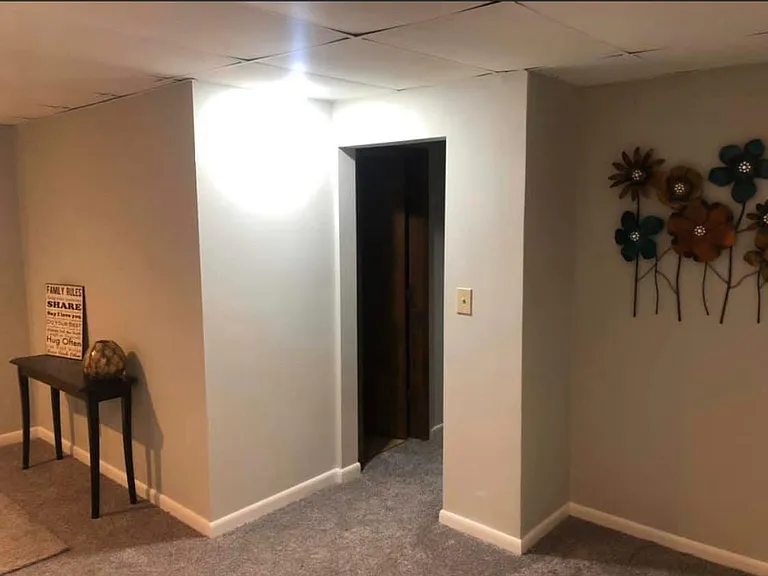 another photo of the extra living space room. the doorway goes to the 2 bedrooms upstairs. the wood door on the left is the bathroom.