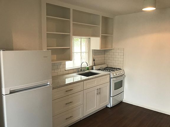 Clean happy white kitchen with gas stove and carrera counter tops. No DISPOSAL.