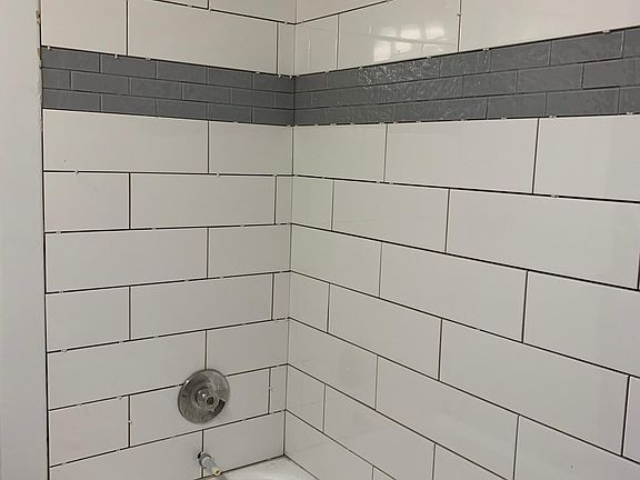 new shower tile. Door trim and wall will be painted. New shower fixtures will be installed