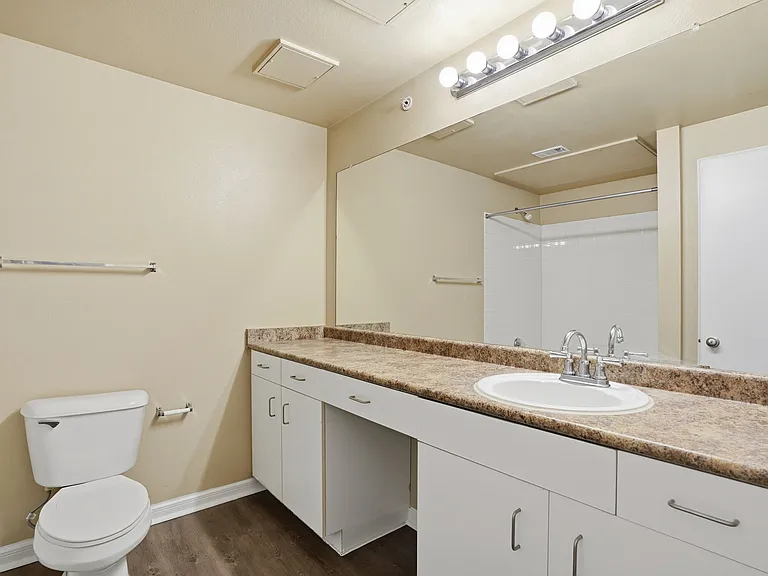 Large Bathroom with ample countertop space, vanity nook for stool and under cabinet storage.