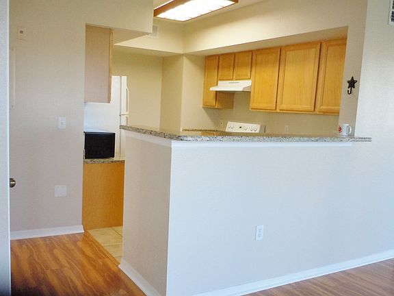 All granite kitchen with breakfast bar opens to living/dinin