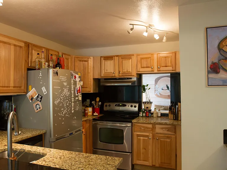 Kitchen with pass-through to living room. Hickory cabinets, and new range.