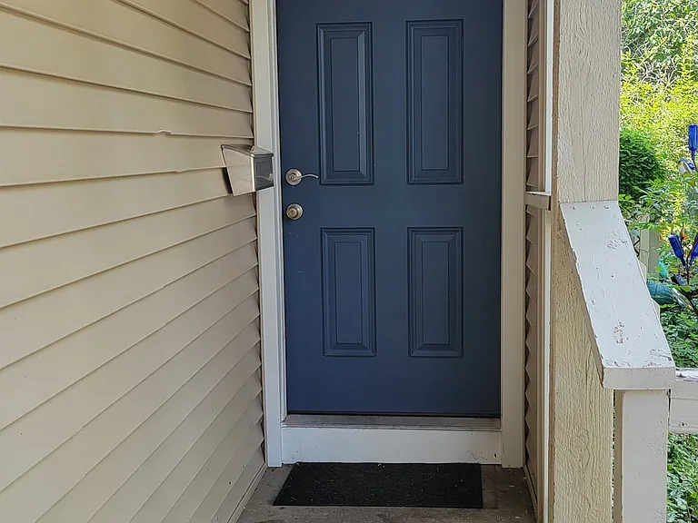 The front door is painted blue to add some color to the tan exterior.
