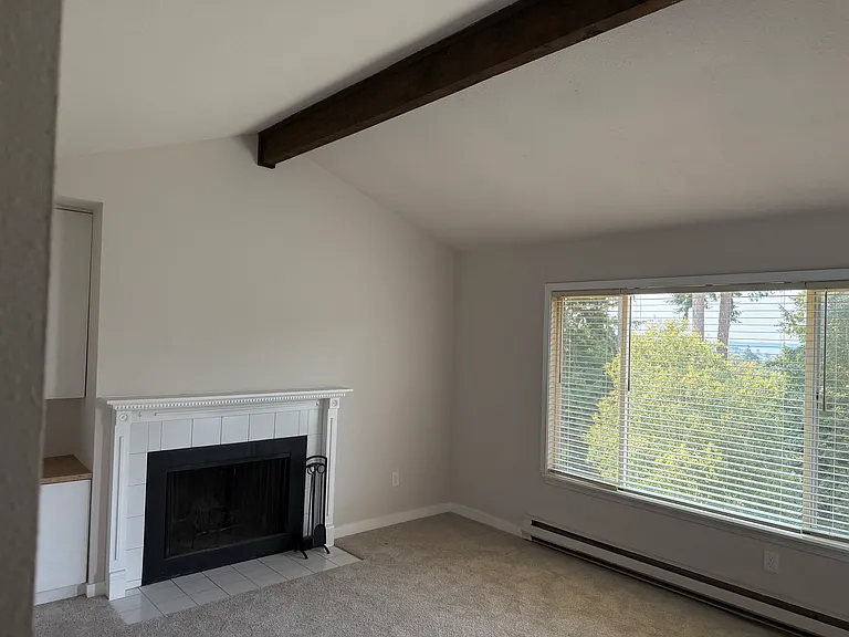Living room with vaulted ceiling and fireplace with mantel