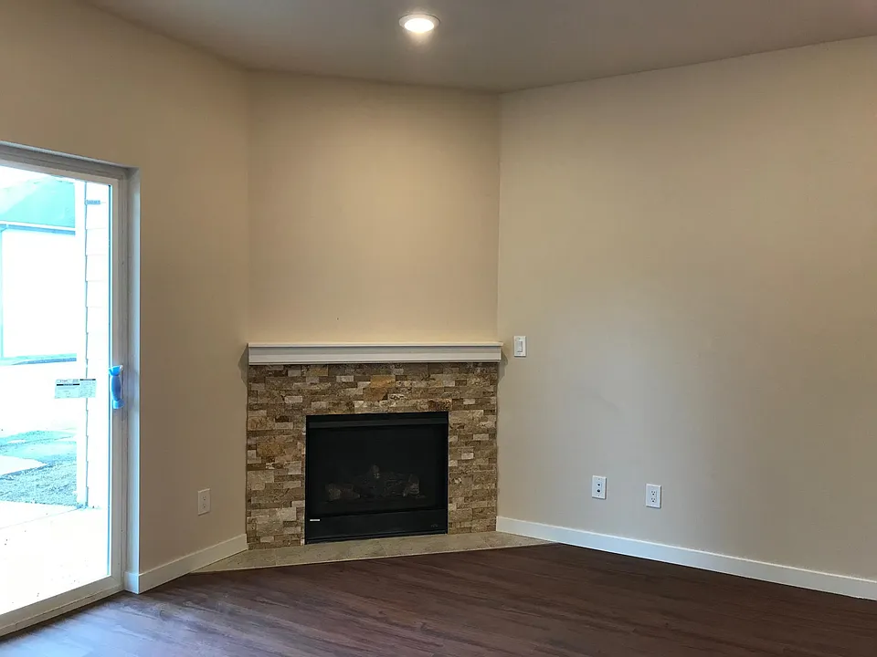 Bright open-concept kitchen and living area featuring durable LVP flooring, center island, ample cabinet space, cozy fireplace, and sliding glass doors that fill the space with natural light.